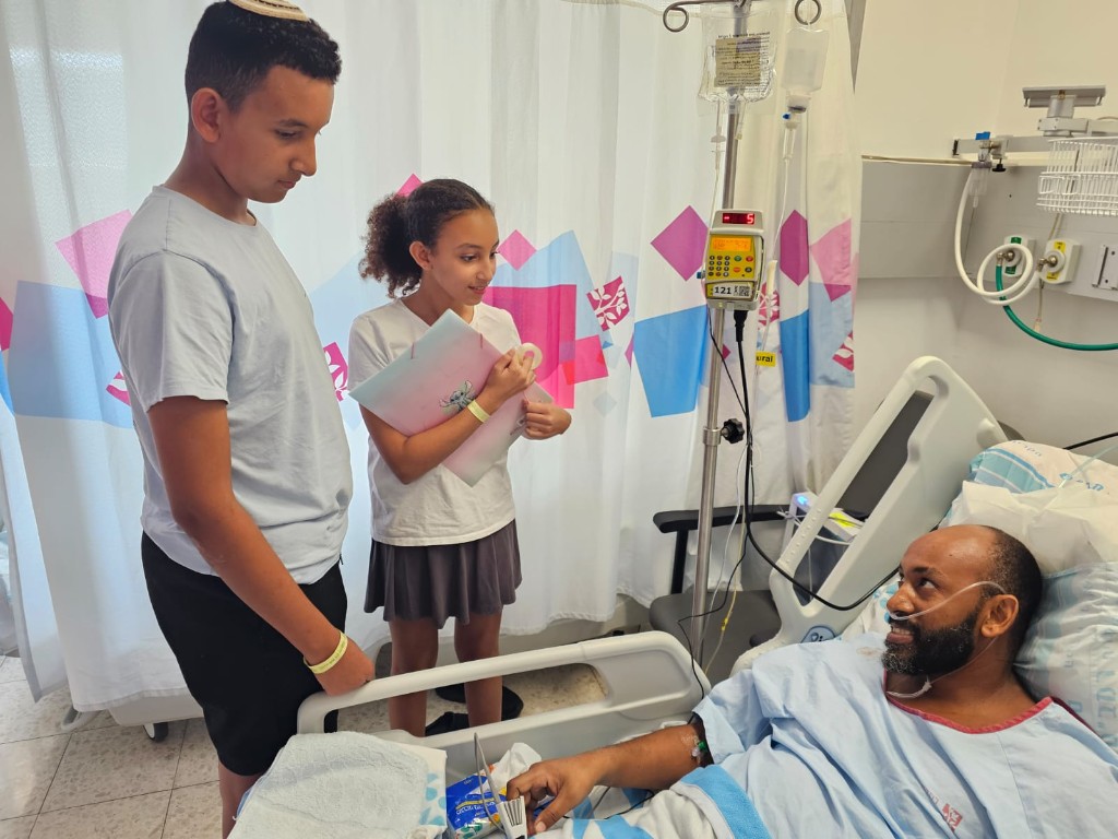 איינאו ממו בבית החולים עם ילדים ליד המיטה